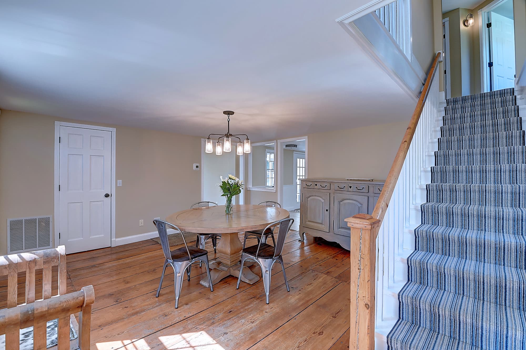 Dining area and historic staircase with original wide-board flooring