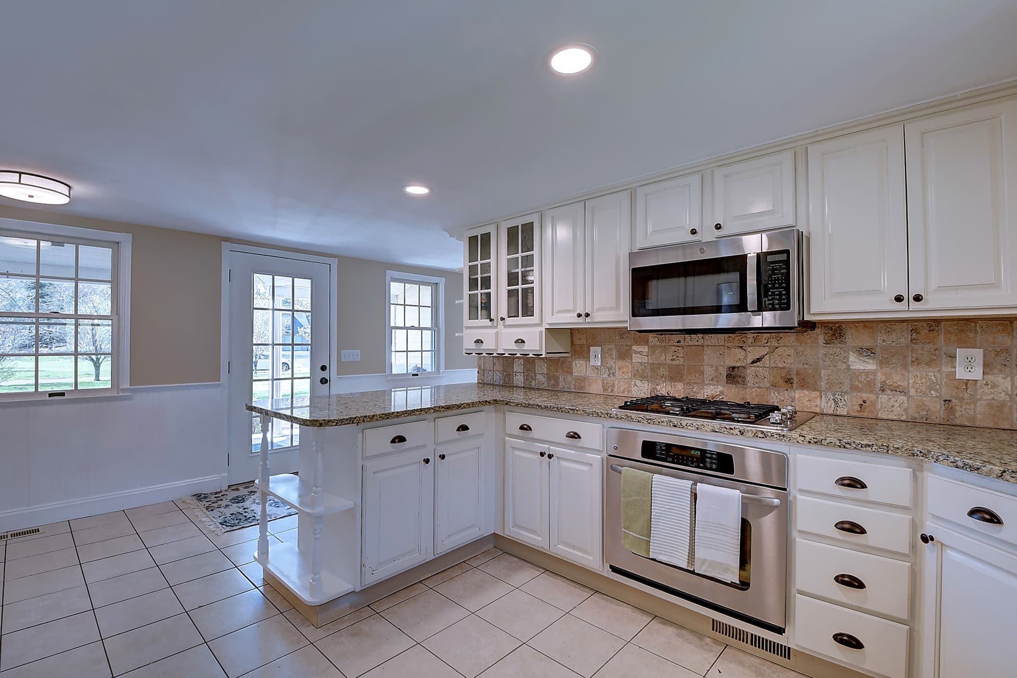 Kitchen view with gas cooktop, wall oven, and breakfast peninsula