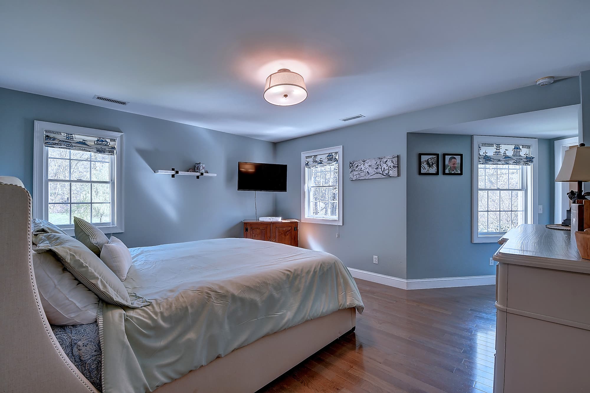 Primary bedroom suite with hardwood flooring and natural light
