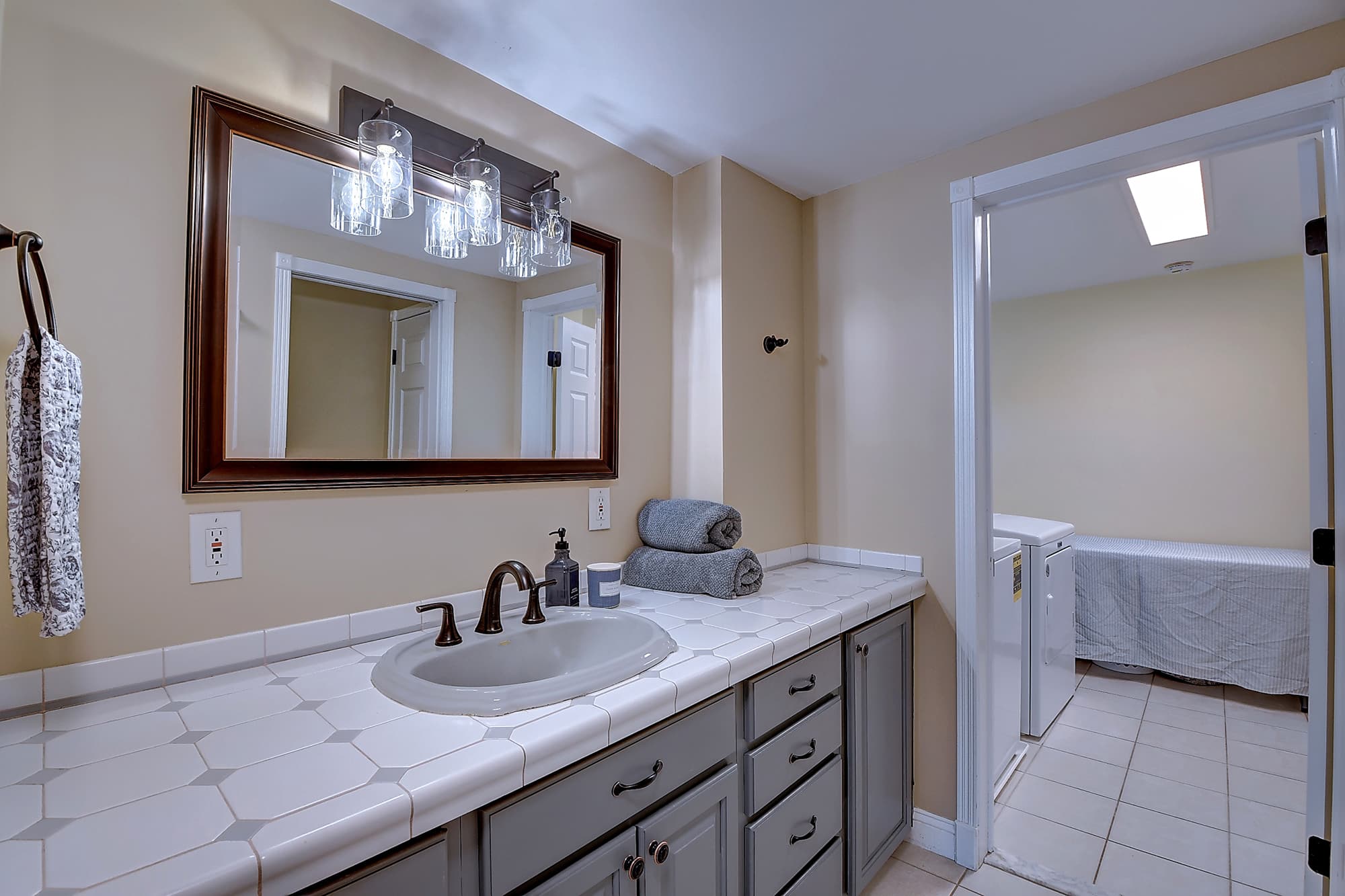 Full bathroom with adjoining upper-level laundry room